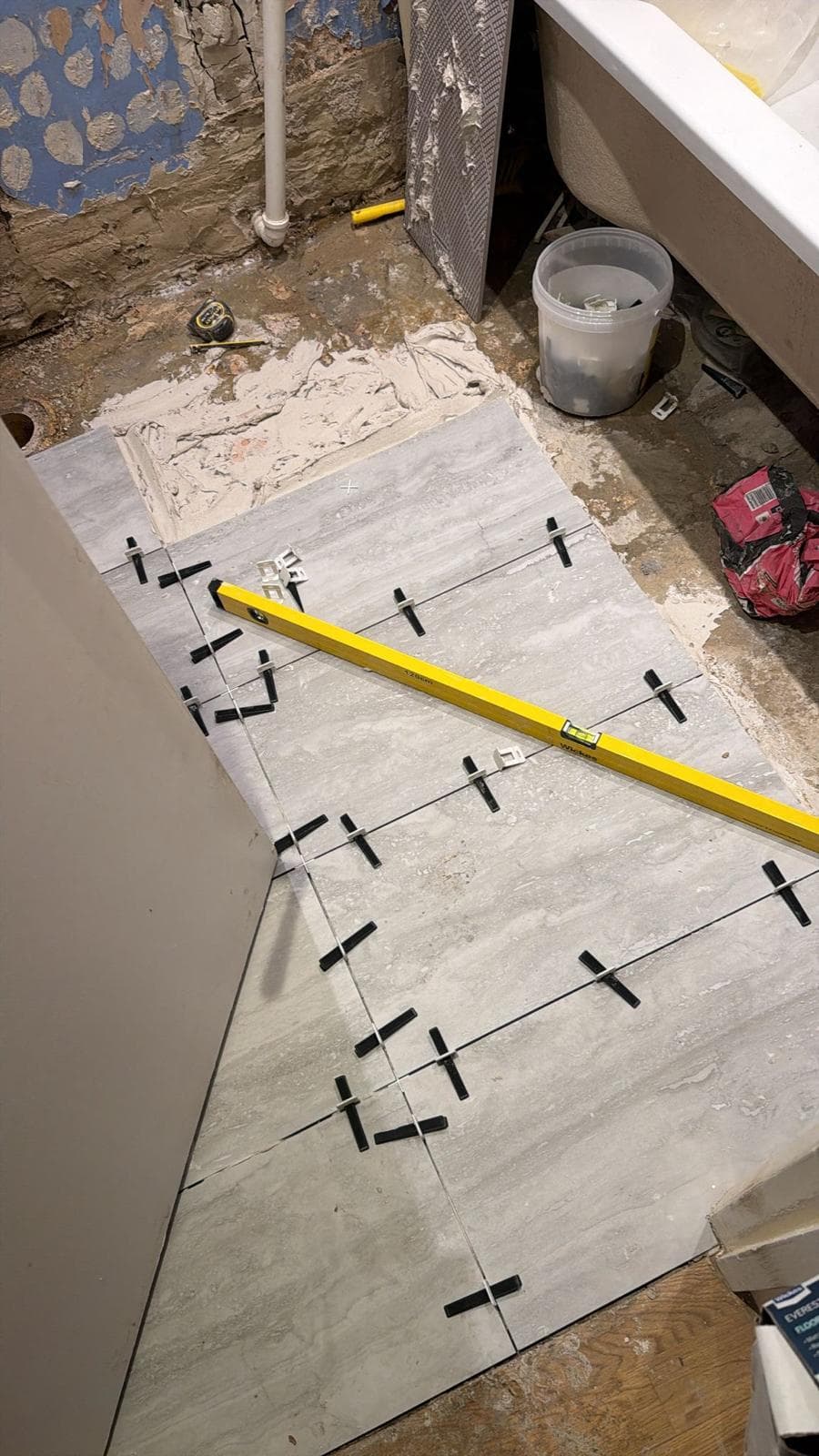 Bathroom Renovation in Brixton: Floor tiles going down on levelling clips
