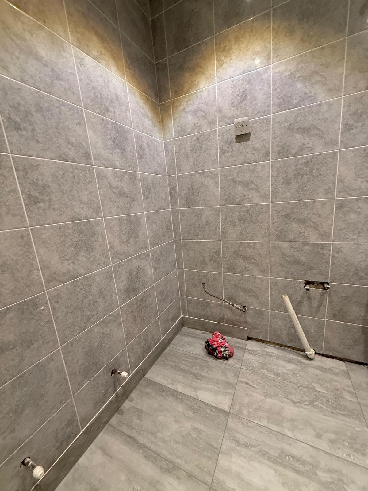Bathroom Renovation in Brixton: Walls and floor tiled, pipework waiting for the sanitaryware