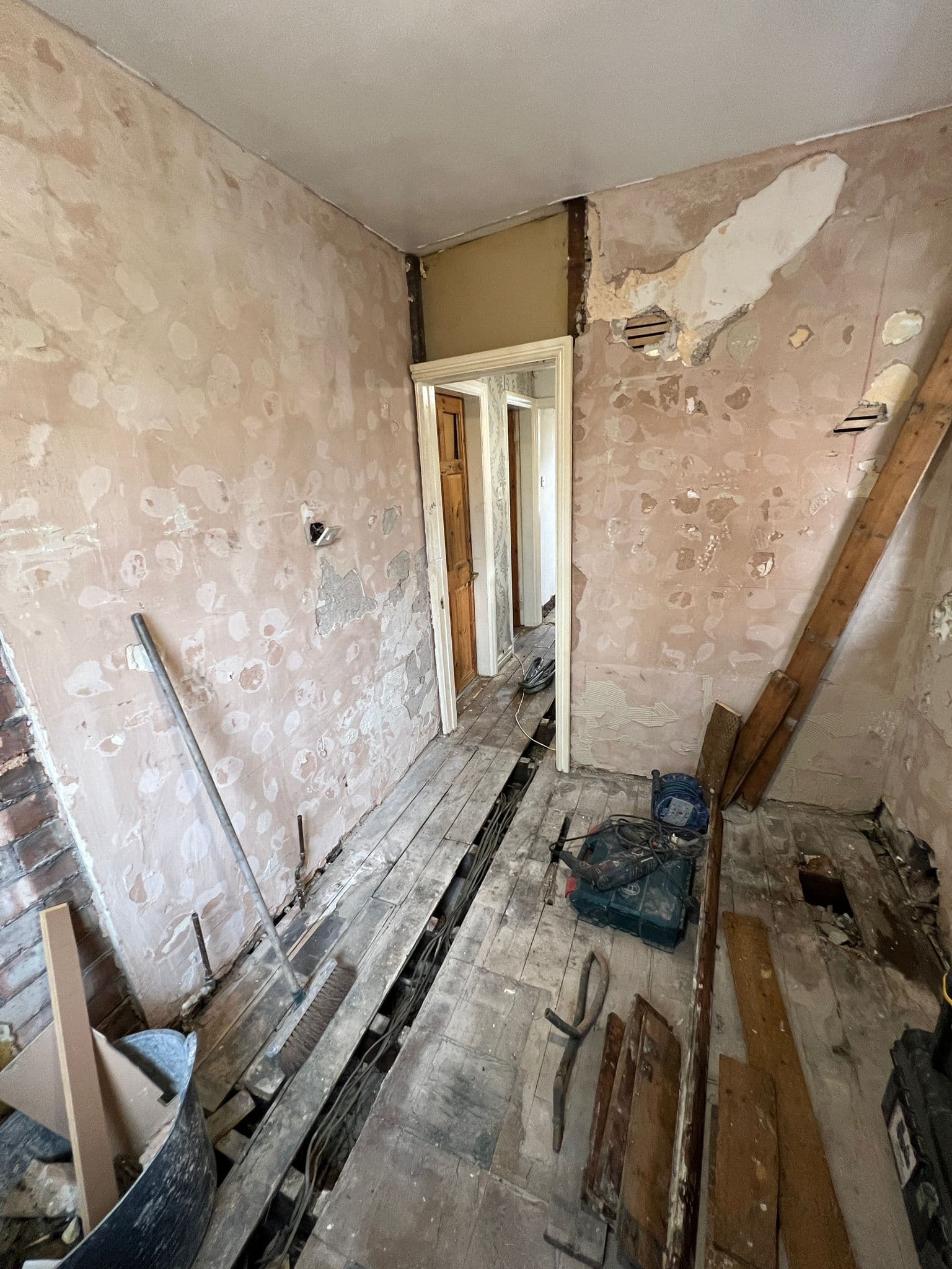 Bathroom to Kitchen Conversion in Chelsea: Walls hacked back, looking through to the hall
