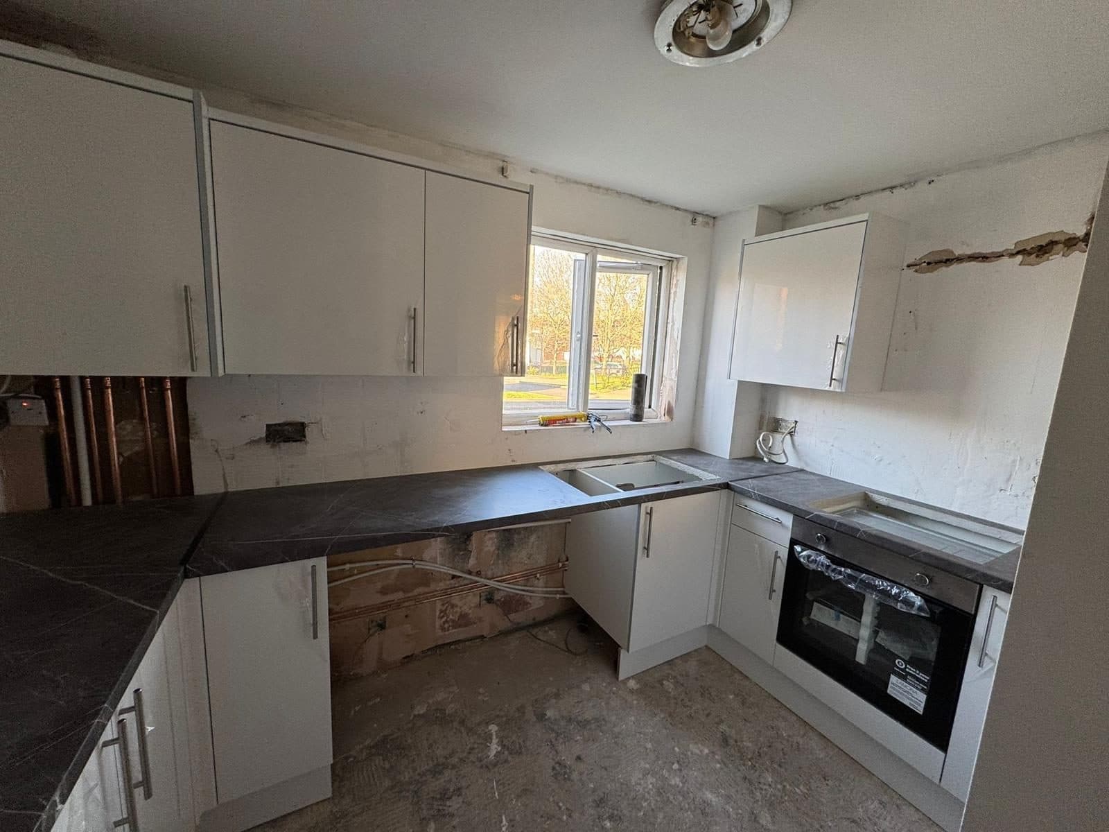Full Property Refurbishment in Hammersmith: New units and worktop going in, with the oven fitted