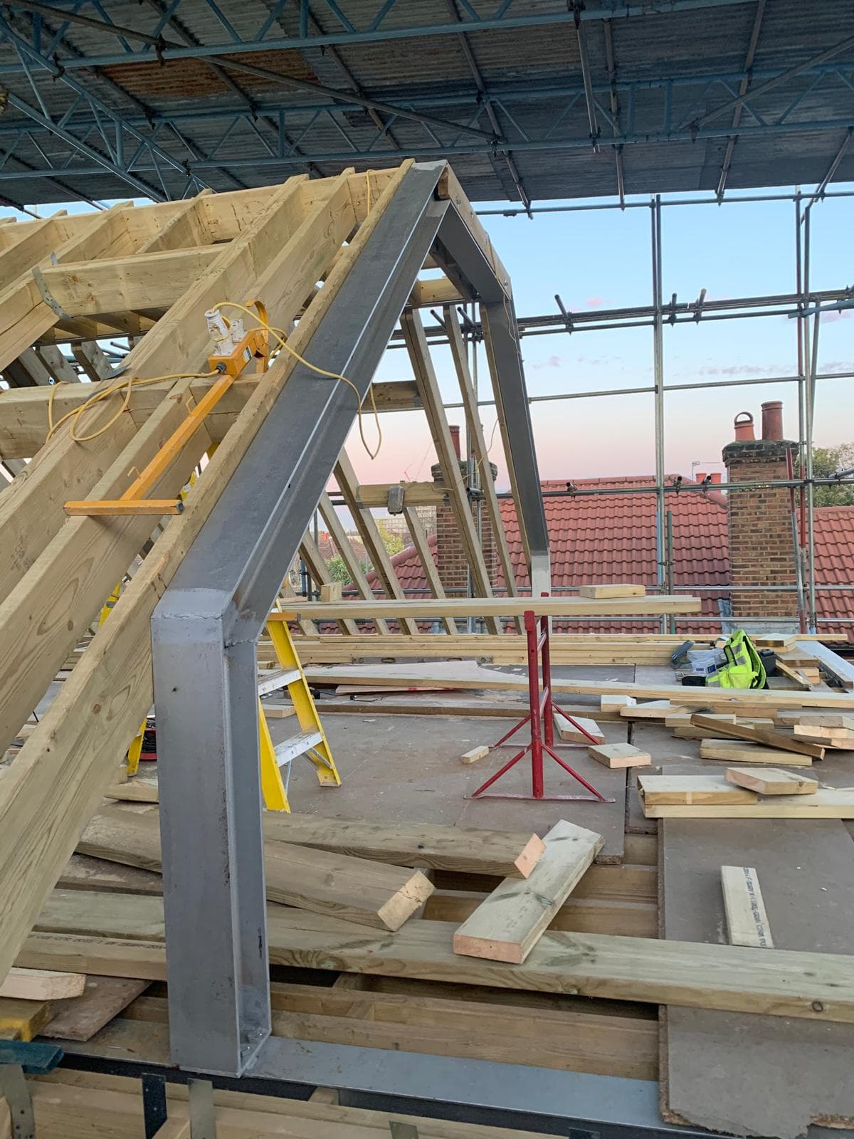 Full House Renovation in Chiswick: Steel frame and new rafters going up at dusk