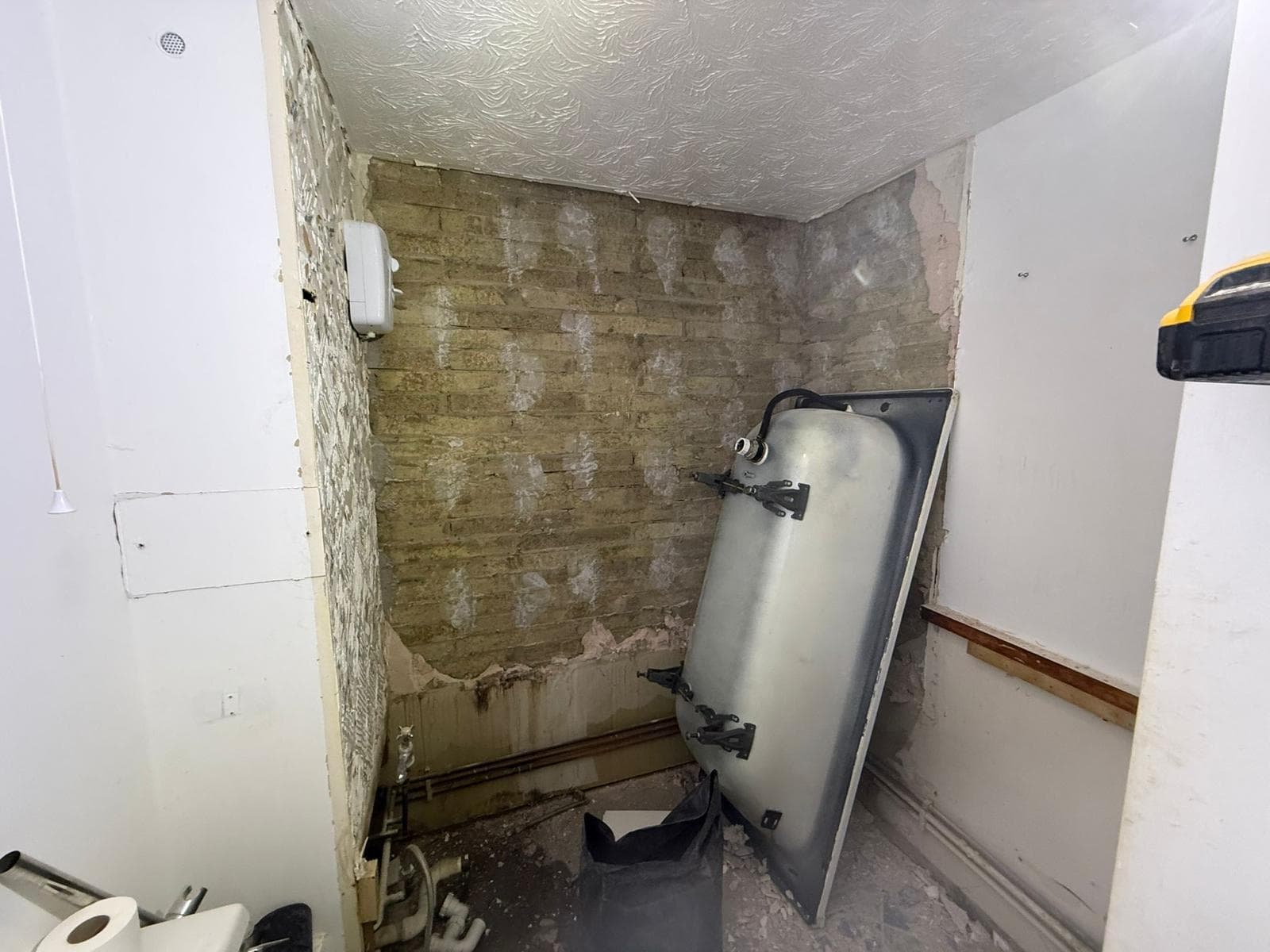 Marble Family Bathroom in Hammersmith: Bath out and the wall stripped back