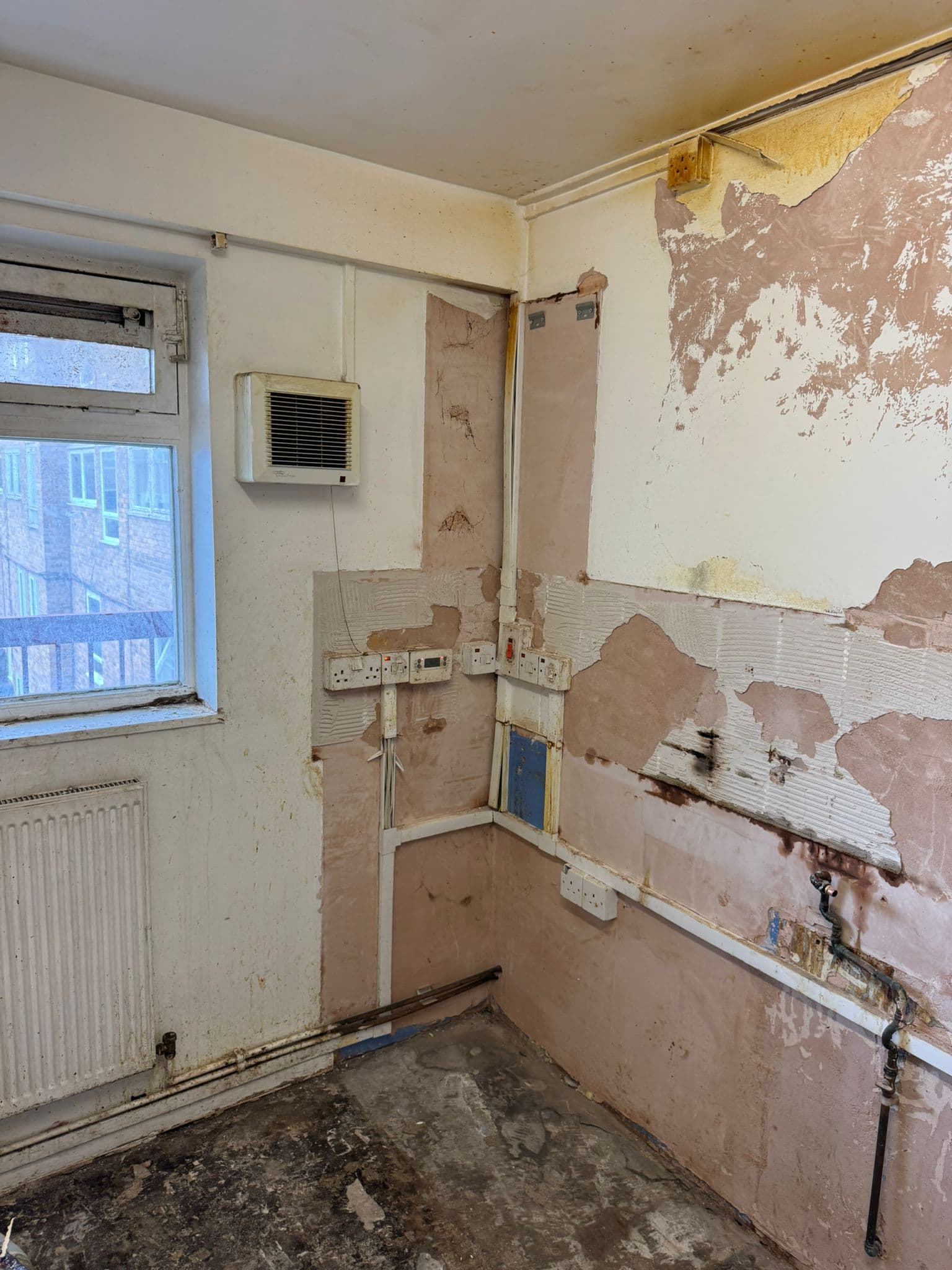 Navy Shaker Kitchen in Mayfair: Old kitchen part-stripped, tiles coming off the wall
