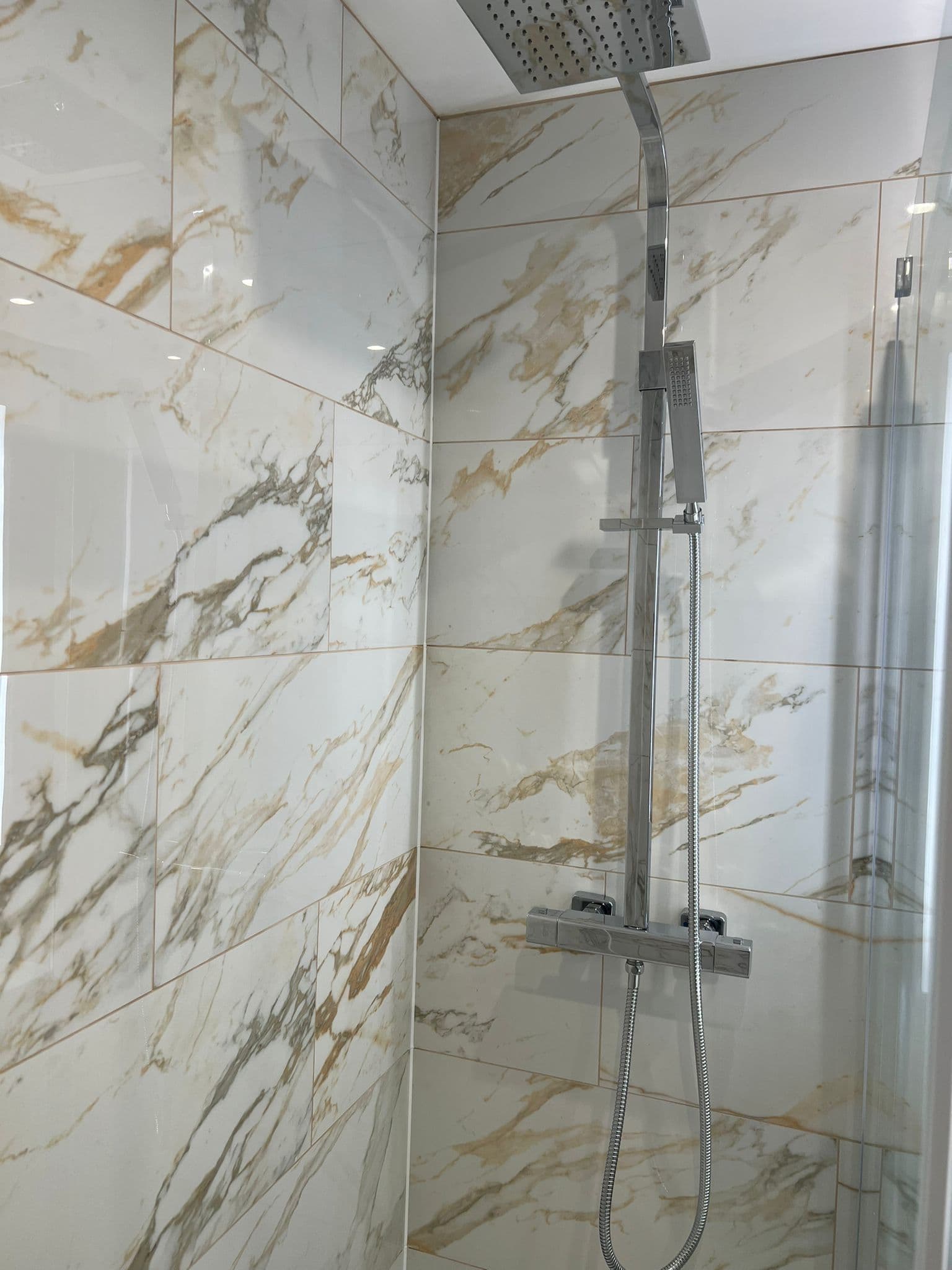 Walk-in Shower Room in Peckham: The shower brassware against the veining