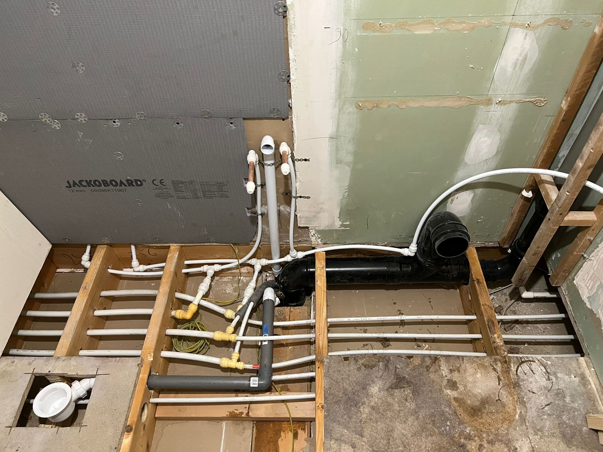 Walk-in Shower Room in Peckham: Floor up: new pipework and the soil run between the joists