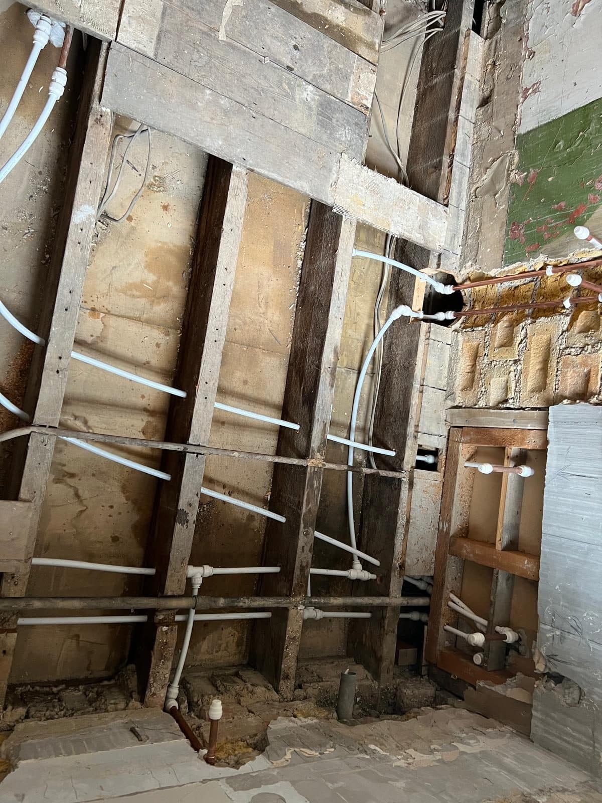 Bathroom Layout Transformation in Tooting: New supply pipes run across the exposed timbers