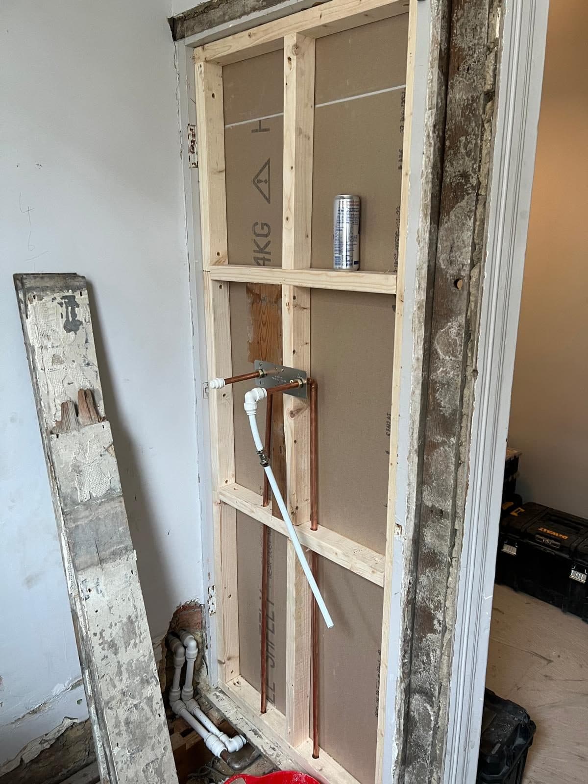 Bathroom Layout Transformation in Tooting: Timber stud framing with new pipework, before boarding