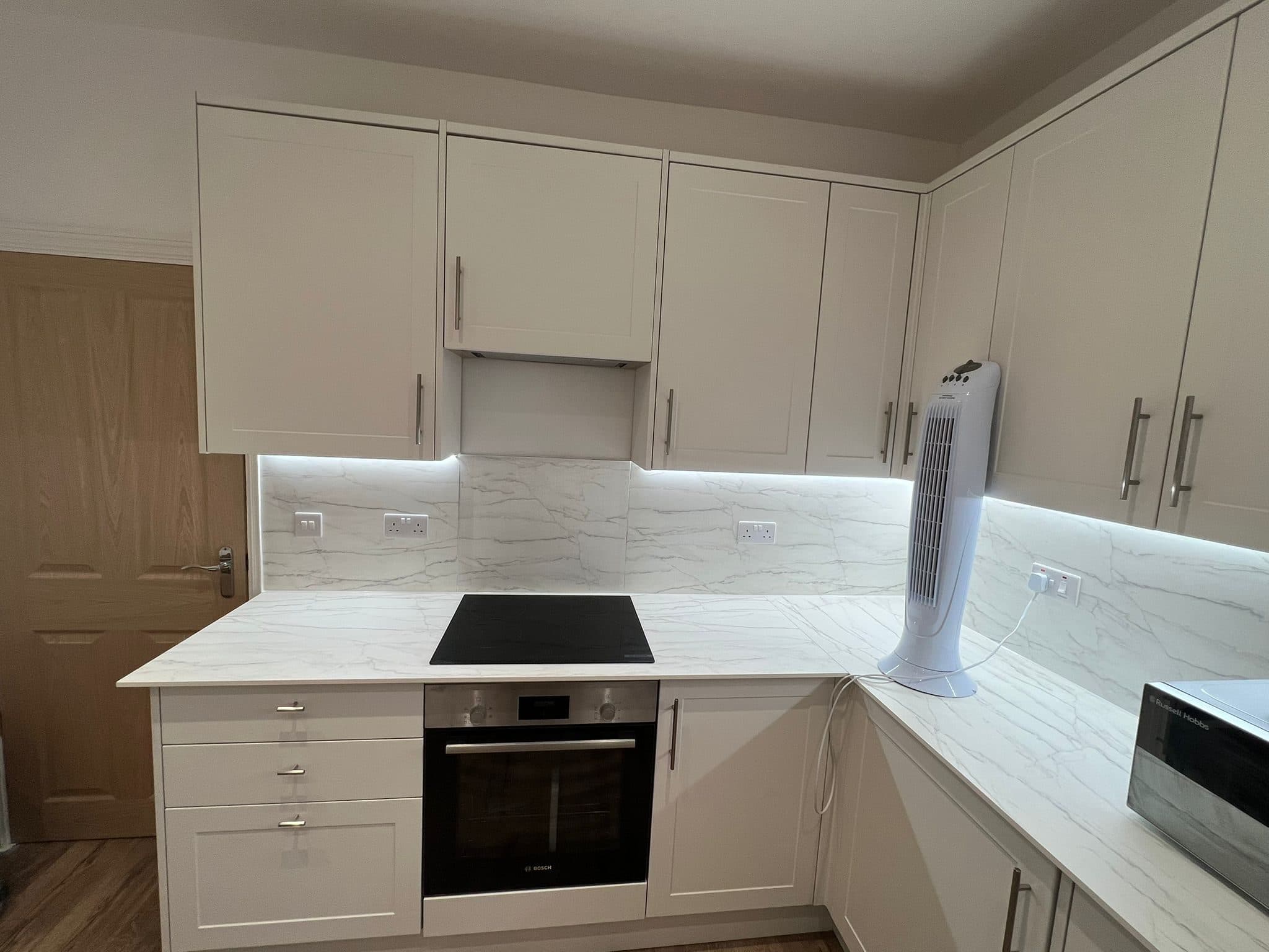 Kitchen Renovation in Tooting: Built-in oven and hob beneath marble-effect splashbacks