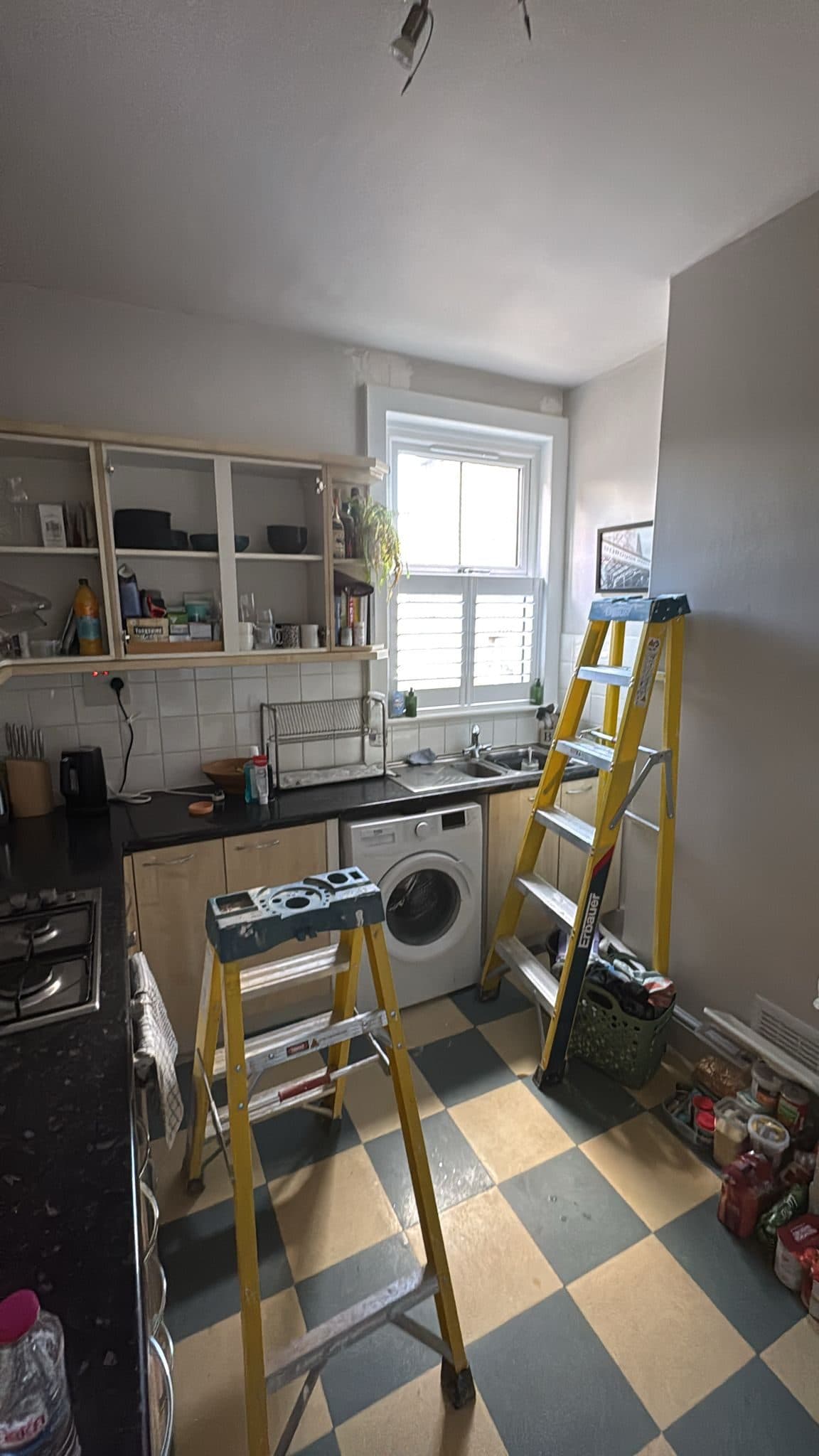 Kitchen Renovation in Tooting: The chequered floor and the sink run beneath the window